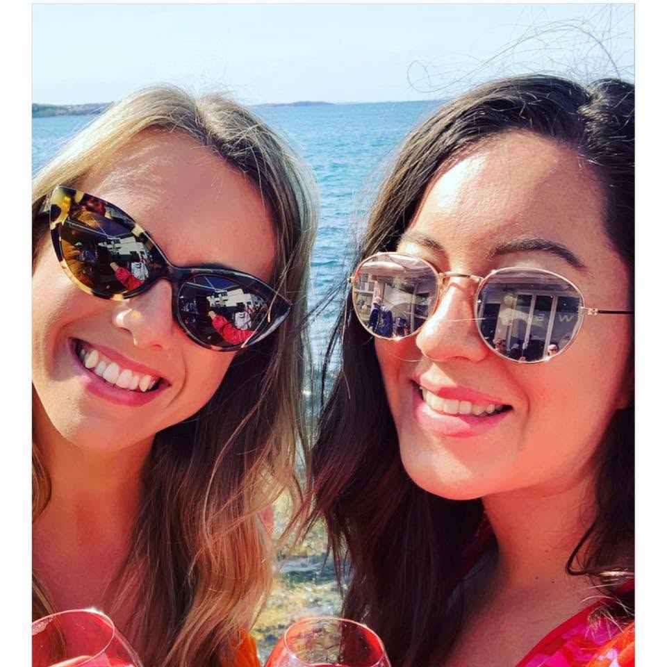 Lauren smiling with a friend beside the sea