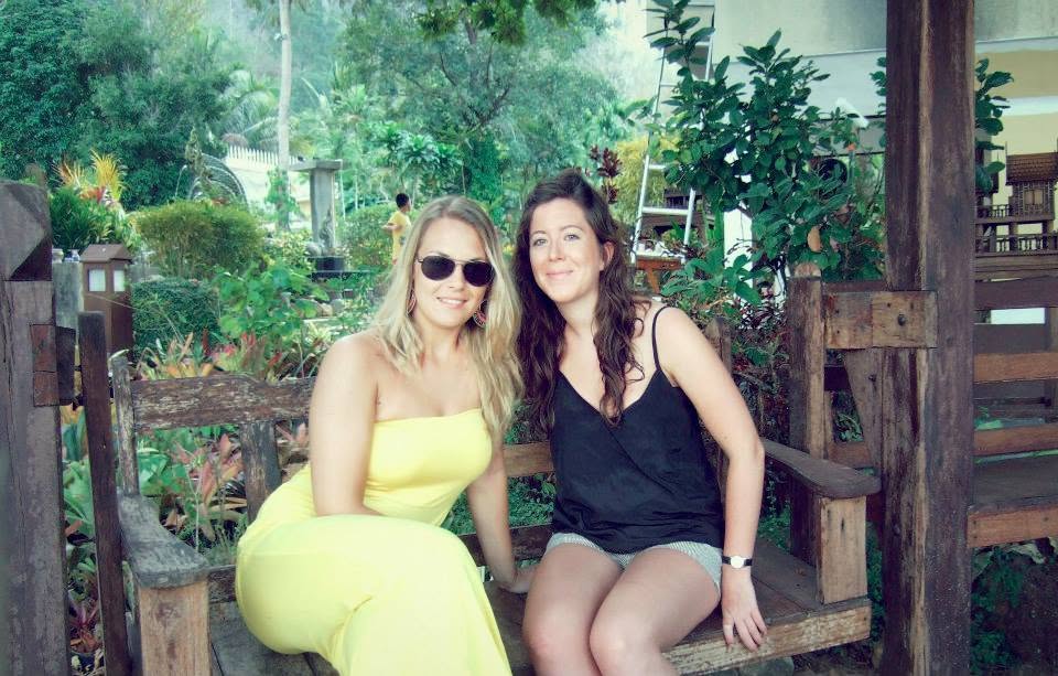 Lauren sitting with a friend in a tropical garden
